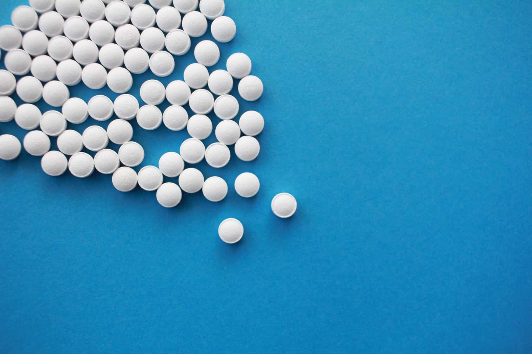 White pills spread out on a blue background.