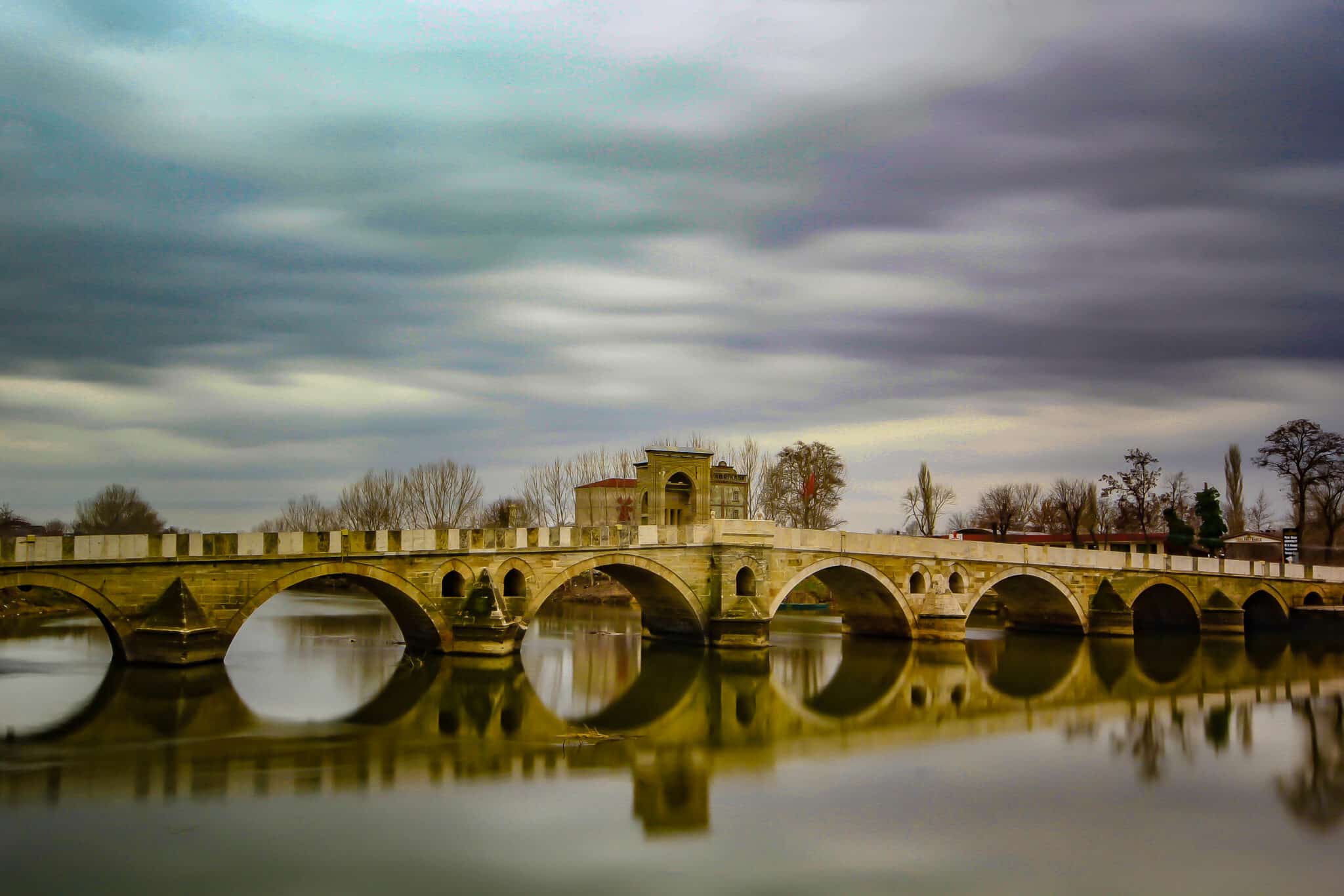 edirne Old arched bridge over peaceful river on overcast day