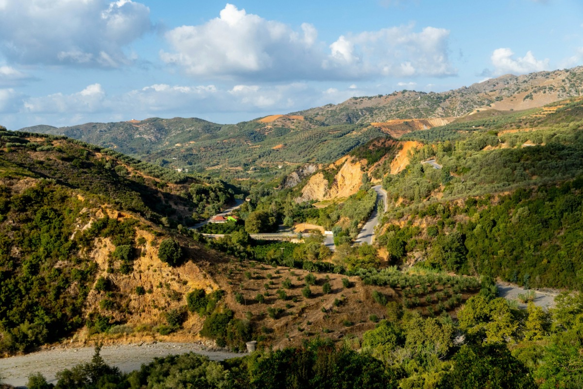 a-scenic-view-of-a-valley-with-a-road-winding